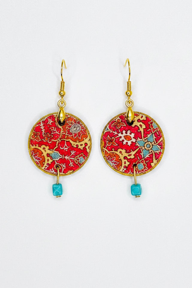 A pair of bohemian-style dangle earrings with circular red and gold embroidered discs, turquoise bead drops, and gold hypoallergenic fishhook wires