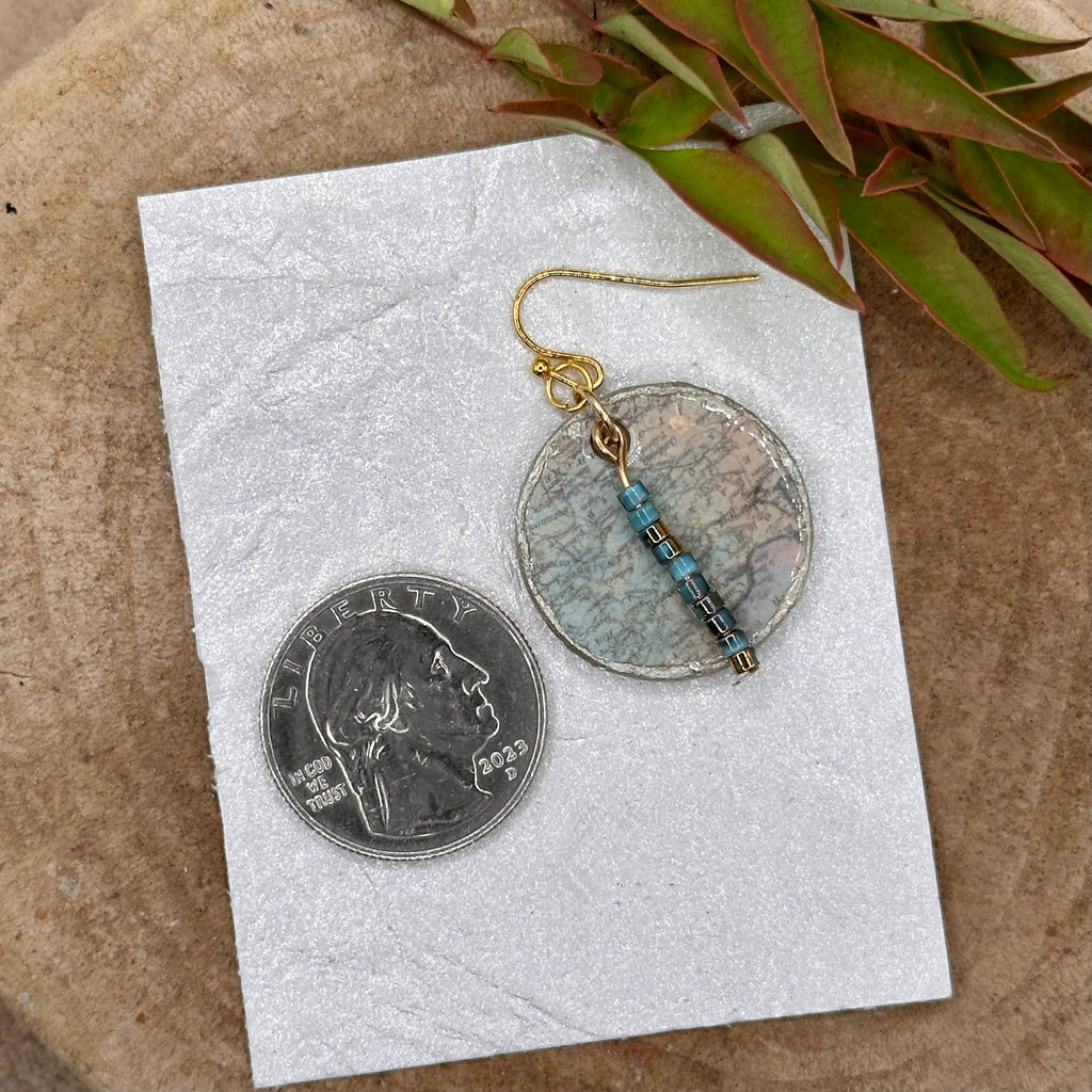 Handmade dangle earrings with a muted recycled map pattern, featuring small &nbsp;bead accents and silver tone hypoallergenic hooks.&nbsp; Sealed with a protective glaze.&nbsp; Light as a feather!