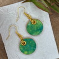 A pair of gold-tone dangle earrings with hand painted round green marbled pendants.  Hypoallergenic, one of a kind.