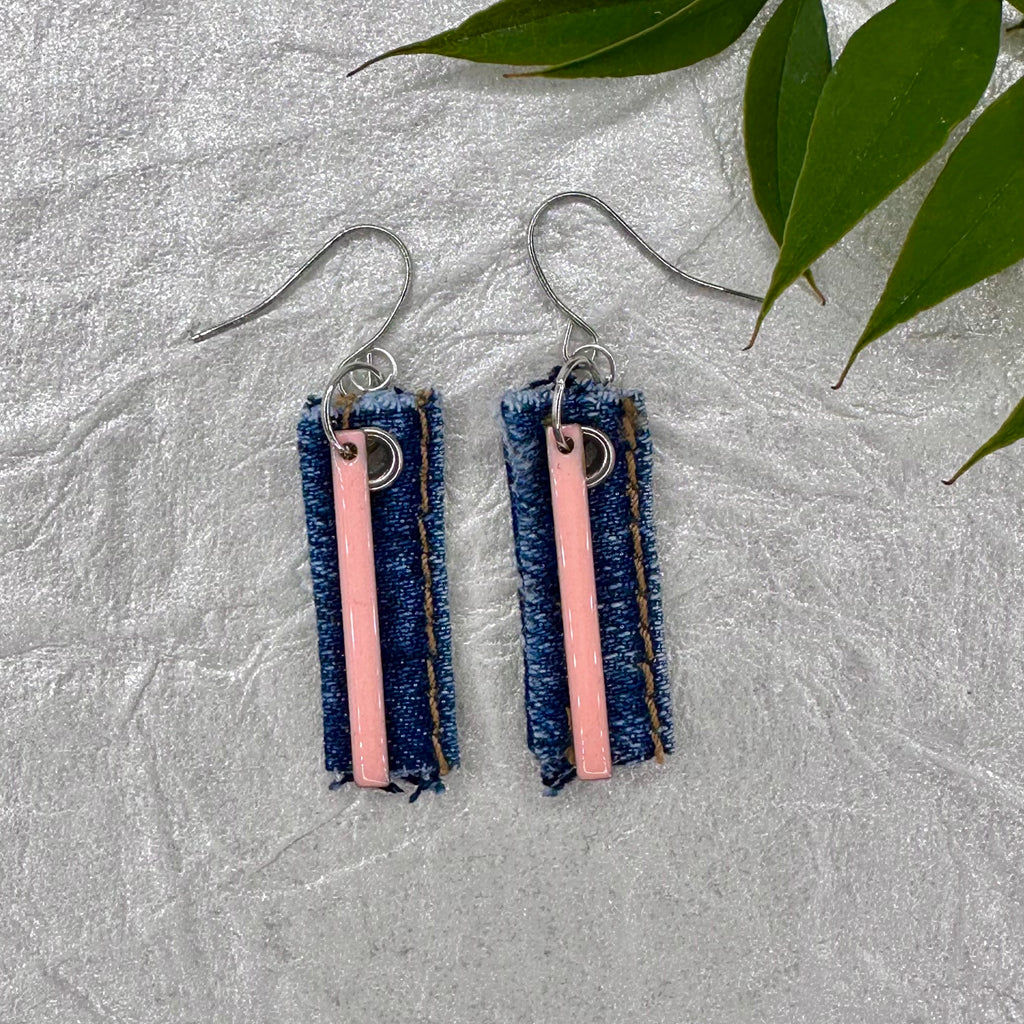 Handmade recycled denim earrings with pink bar charm. Hypoallergenic silver tone fishook earring wires. Casual, lightweight and fun to wear! 1.25” long not including the earring wires.