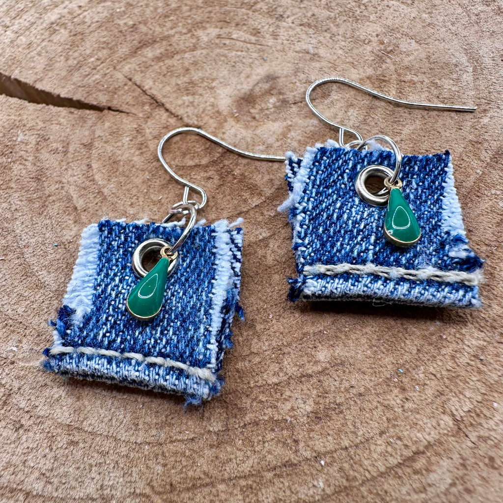 A pair of handmade square denim dangle earrings with silver fishhook wires and green teardrop charm.
