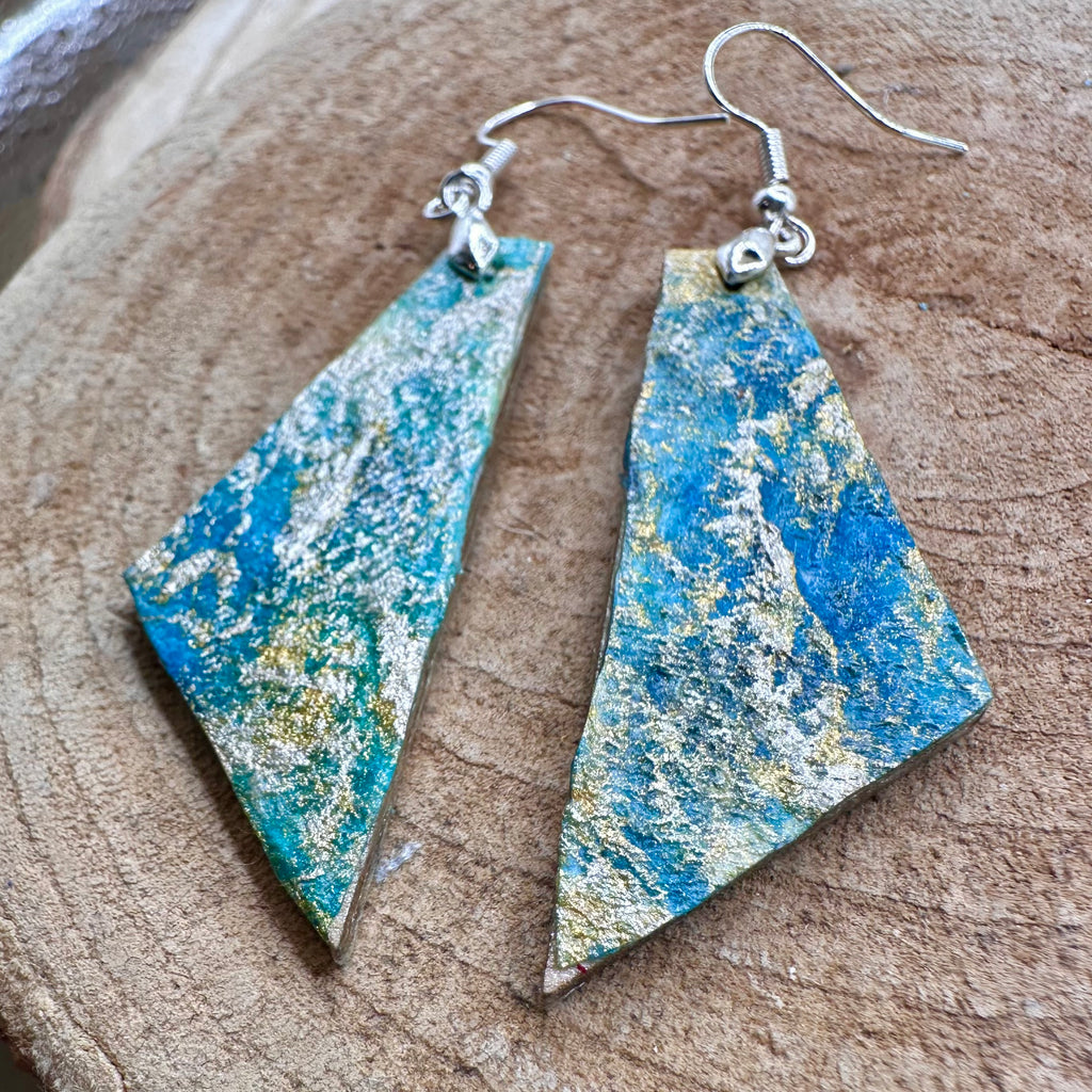 Hand painted geometric earrings in marbled teal, green, and gold textured with silver-tone fishhook wires. Sealed with a protective mat varnish. &nbsp;Hypoallergenic and light as a feather.&nbsp; &nbsp;2” long not including earring wire.