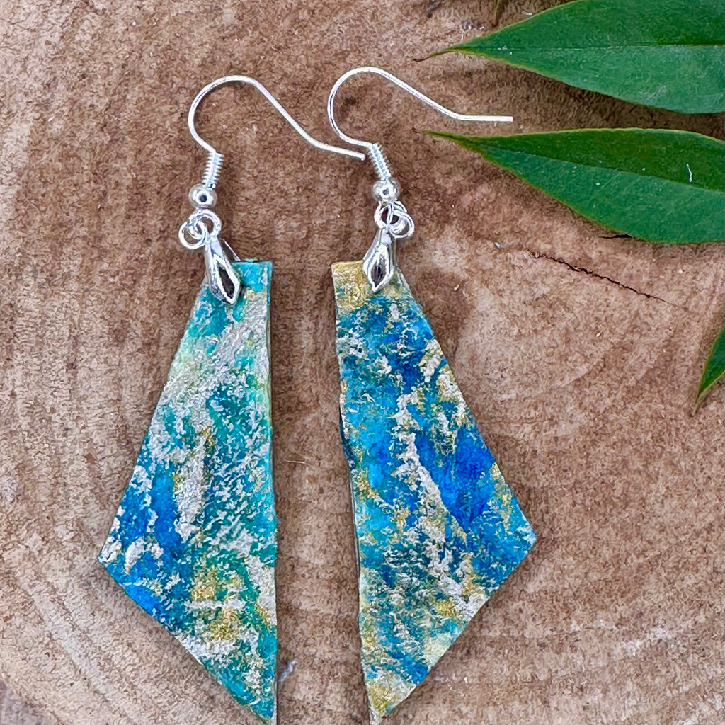 Hand painted geometric earrings in marbled teal, green, and gold textured with silver-tone fishhook wires. Sealed with a protective mat varnish. &nbsp;Hypoallergenic and light as a feather.&nbsp; &nbsp;2” long not including earring wire.