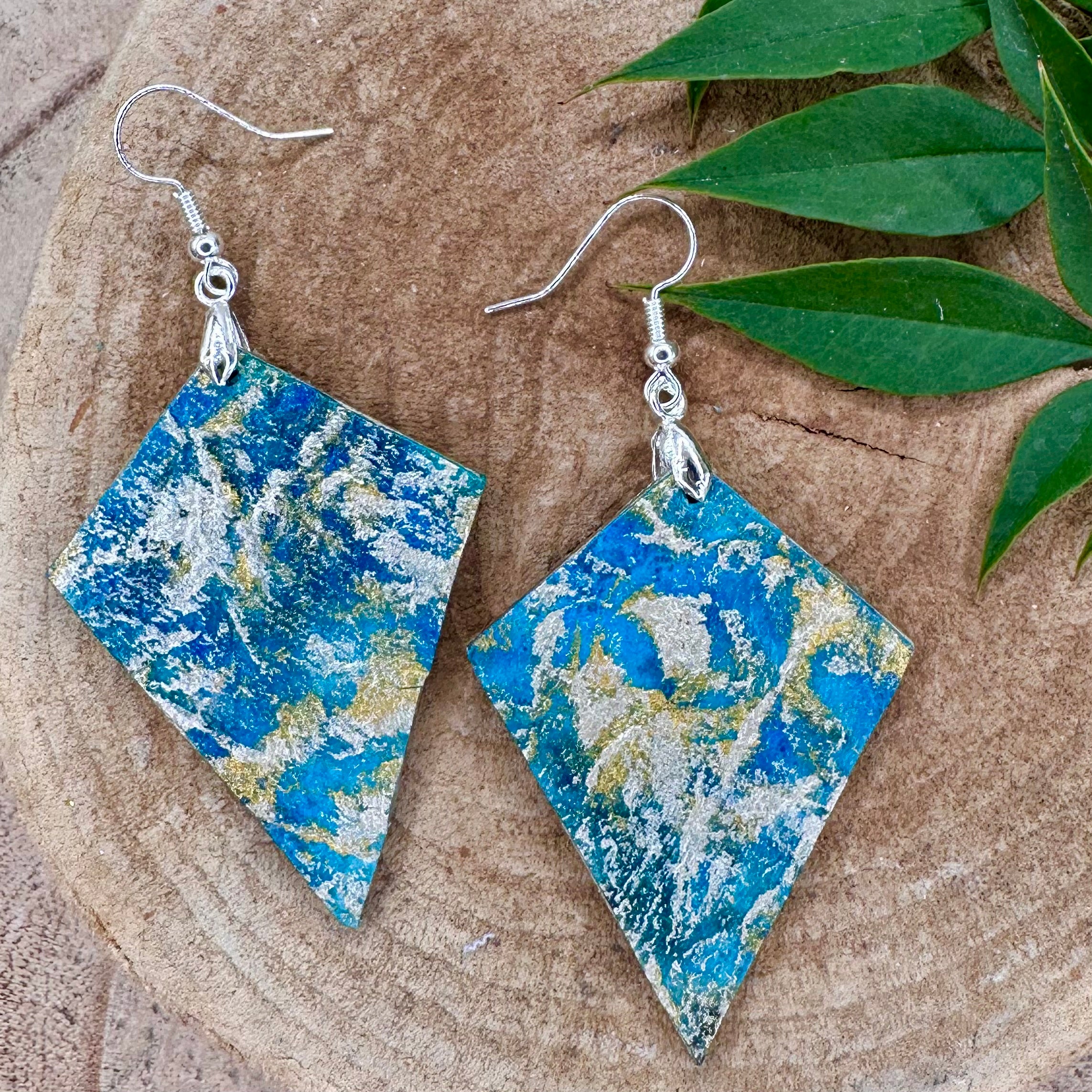 Hand painted earrings in marbled teal, green, and gold textured with silver-tone fishhook wires and diamond-shaped pendants. Sealed with a protective mat varnish.  Hypoallergenic and light as a feather. 2" long not including the earring