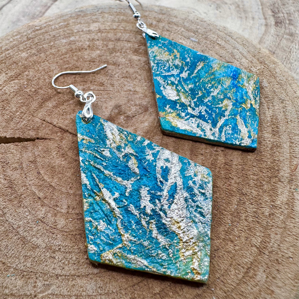 Hand painted earrings in marbled teal, green, and gold textured with silver-tone fishhook wires and diamond-shaped pendants. Sealed with a protective mat varnish. &nbsp;Hypoallergenic and light as a feather.&nbsp; 2” long not including earring wire