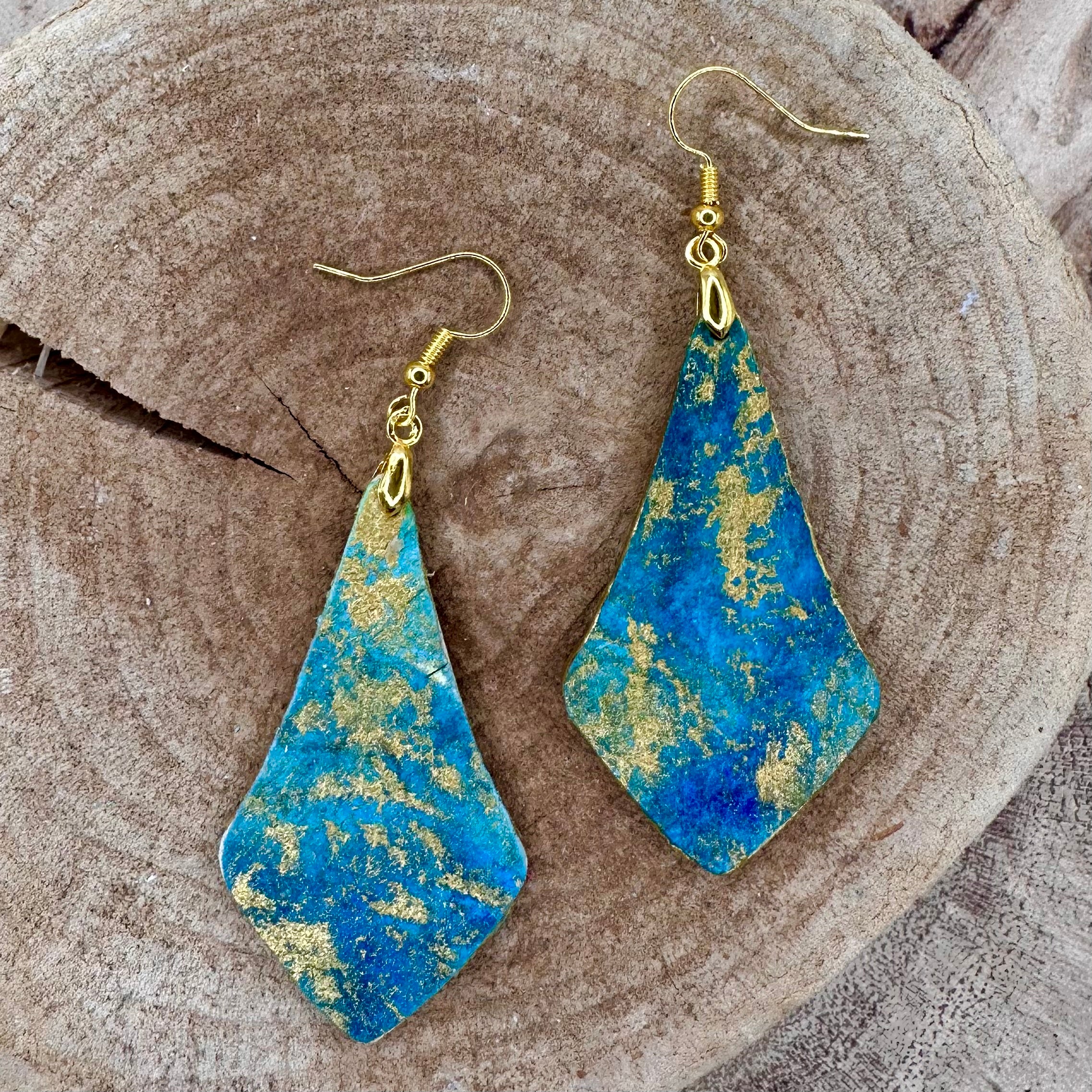 Hand painted earrings in marbled teal, green, and gold textured with gold-tone fishhook wires and diamond-shaped pendants. Sealed with a protective mat varnish. &nbsp;Hypoallergenic and light as a feather.&nbsp; 2” long not including earring wire.