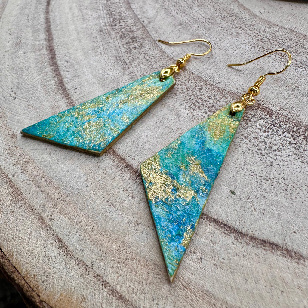 Hand painted earrings in marbled teal, green, and gold textured with gold-tone fishhook wires. Sealed with a protective mat varnish. &nbsp;Hypoallergenic and light as a feather.&nbsp; &nbsp;2” long not including earring wire.